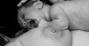 Photo d'un bébé qui pleure au sein pour illustrer l'article sur la frénectomie. 