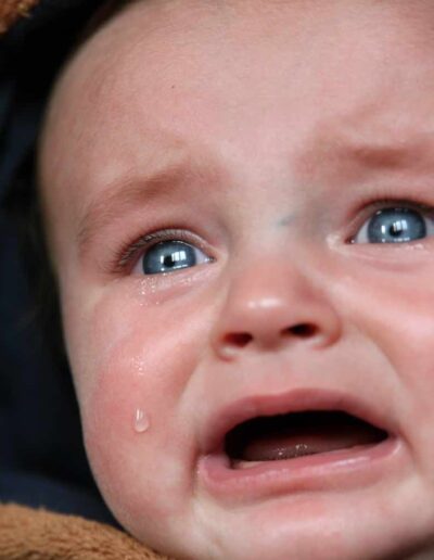 Photo d'un bébé en pleur pour illustrer les souffrances que les freins retsrictifs font subir aux bébés et aux jeunes enfants.