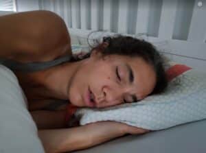 Image d'une adulte dormant la bouche ouverte pour illsutrer les dangers de la respiration buccale et l'apnée du sommeil. 