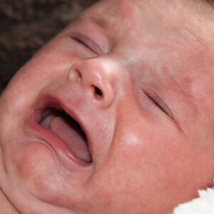 Photographie d'un bébé en larme souffrant de coliques.