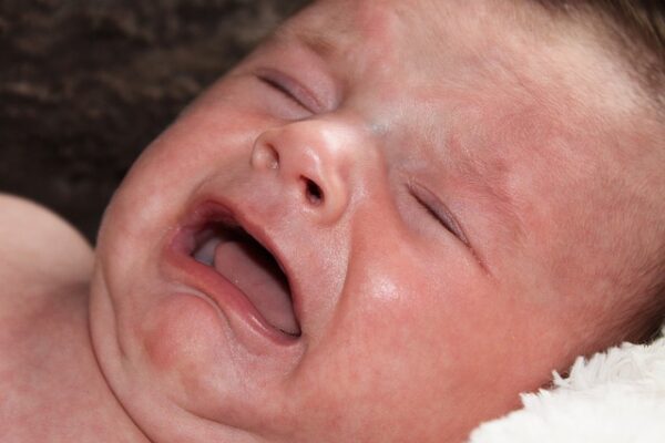 Photographie d'un bébé en larme souffrant de coliques.