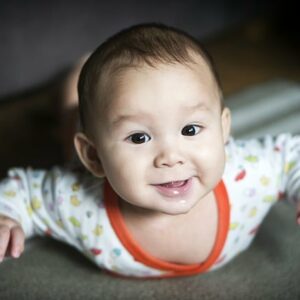 Photo représentant un bébé heureux en tummy time.