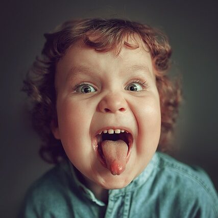 Photographie montrant un enfant tirant la langue ors de l'évalution de ses restrictions linguales.