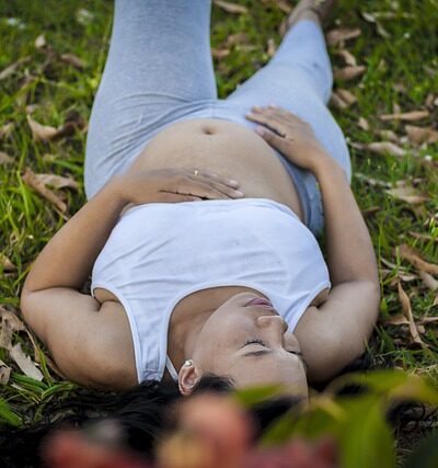 Photo représentant une femme enceinte couchée et respirant par la bouche pour illustrer le risque de prééclampsie.