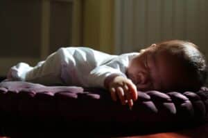Image représentant un bébé endormi sur le ventre pour illustrer le point sur la prise en charge préventive de la bronchiolite. 