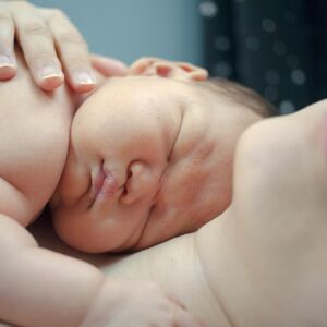 Photographie d'un bébé endormit en peau à peau avec sa maman pour illustrer la conférence sur le sommeil du nourrisson.